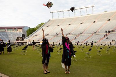 Newly graduated students toss their caps