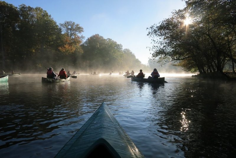 People kayaking on a misty river.