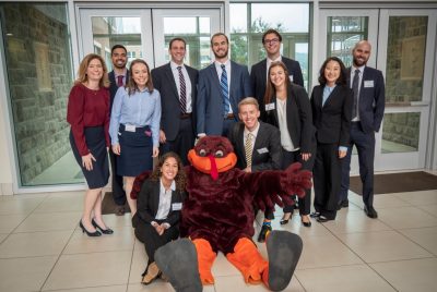 Eleven men and women pose with Virginia Tech's mascot, the HokieBird.