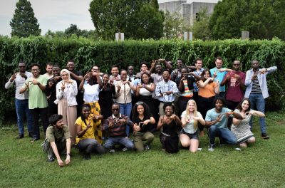 A group of new graduate students gathered in the Graduate Life Center courtyard and practiced making the VT sign with their hands. Lots of smiles.