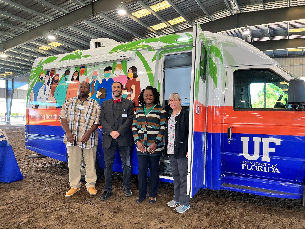 Gutter and LaToya O’Neal with colleagues from University of Florida Health in front of the new Extension Mobile Health Vehicle at an immunization event