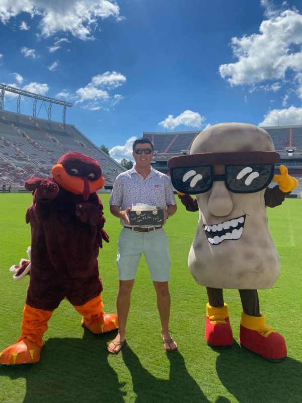 The HokieBird, Brett Smith, and Whitley’s Peanut Factory’s mascot, Whit, on the field of Lane Stadium with the first delivery of peanuts before the Boston College game. Photo courtesy of Maggie Menoni.