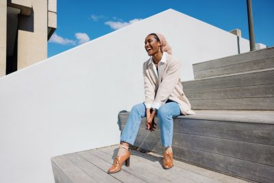 Safyque xRichardson, the winner of the Phi Beta Kappa Wilson essay contest for undergraduates, laughs while sitting against a white backdrop near Cowgill Hall at Virginia Tech. 