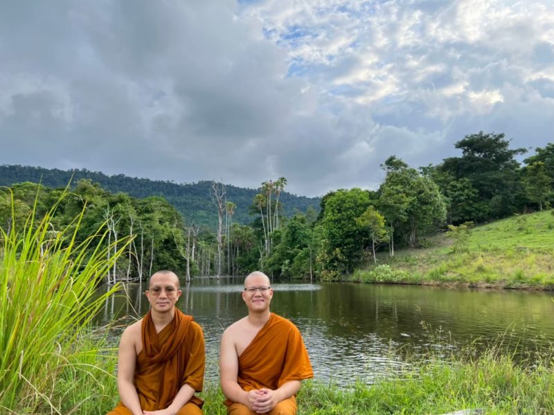 Sukthavorn with Monk Anuchon pictured in front of a pond at which Sukthavorn would feed fish nearly every Friday.