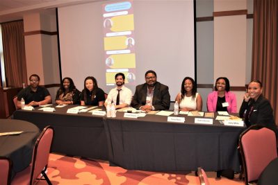 Eight graduate students sitting at a long table at the graduate student panel during the HBCU/MSI Research Summit