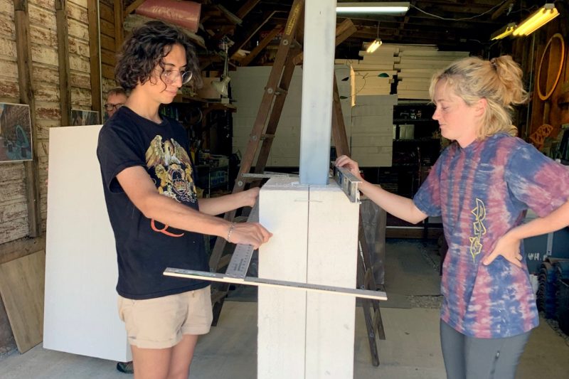 Two interns, Virginia Tech studio art student Is Maturano (at left) and Hannah Walters, work withon one of the two conrete thresholds 
