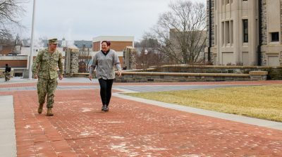 Corps of Cadets Alumni Director Cmdr. Nate Brown and Assistant Alumni Director Lt. Col. Edie Marie Mangibin Fairbank walk on the Upper Quad.