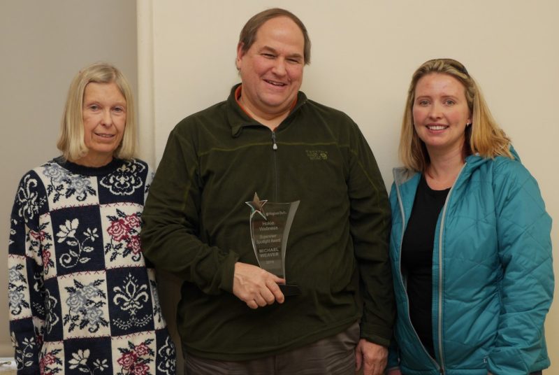 Michael Weaver is presented his award by two employees, Holly Gatton and Susan Terwilliger .