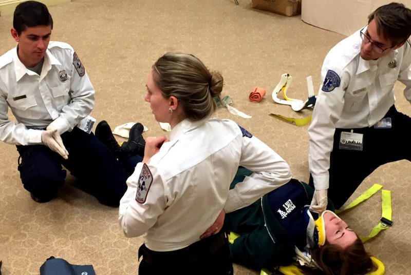 Three members of the ALS skills team attend to a patient. 