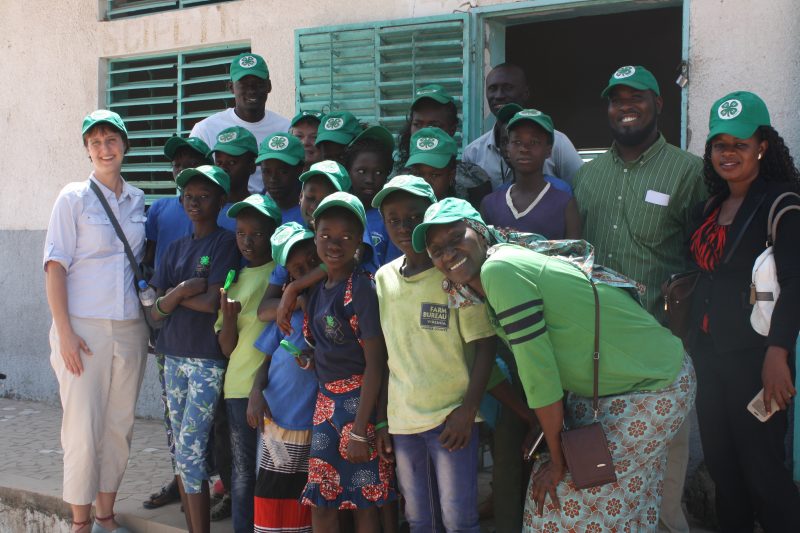 A group of children in Senegal, Africa stands with a Virginia Cooperative Extension 4-H Youth Development agent.