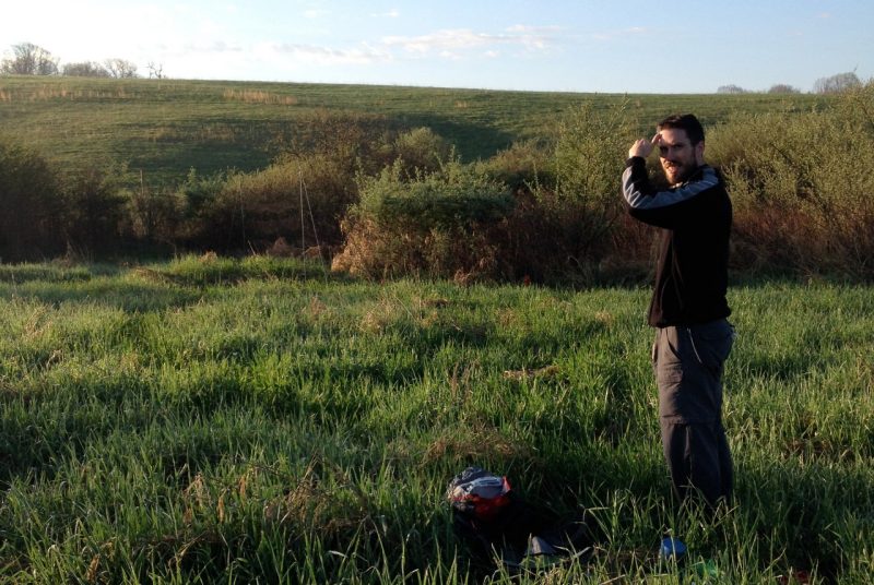Scott Davies looks for birds in a field.