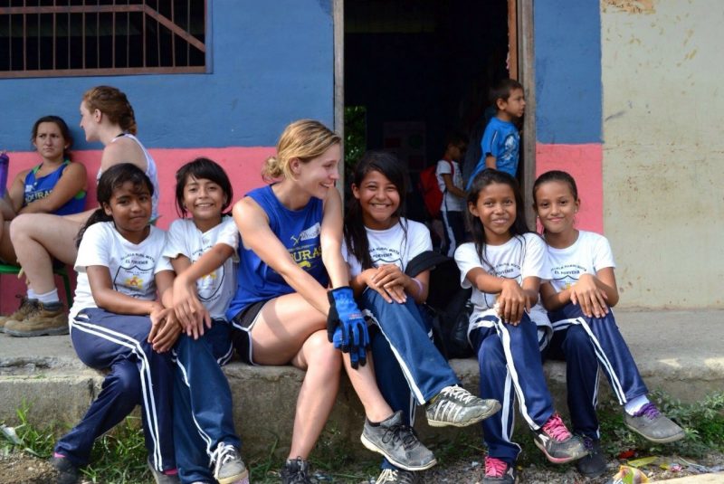 Rhiannon Hasenauer sitting with Honduran schoolchildren