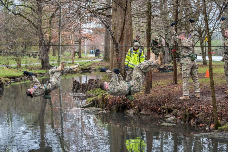 Cadets use ropes to make their way across Stroubles Creek above the water.