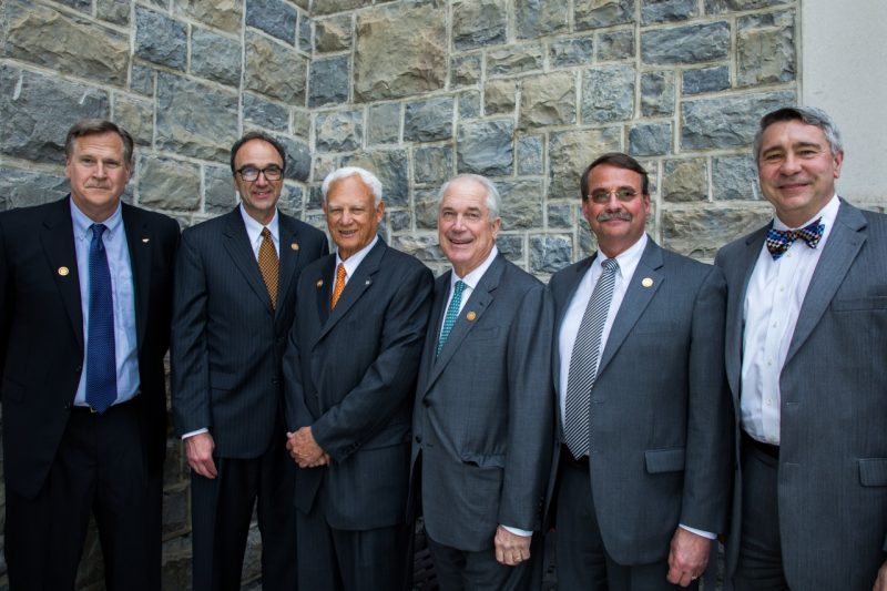 A photo of the five inductees and the interim dean smiling with a Hokie stone backdrop.