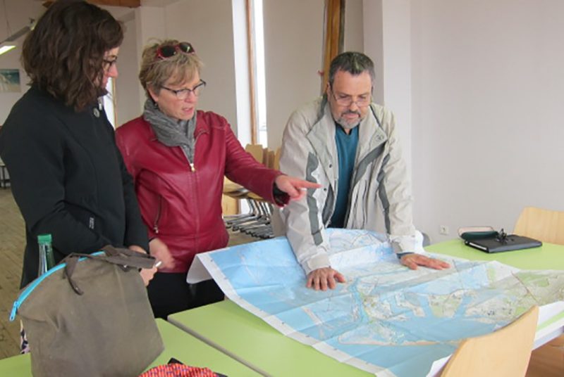 Left to right, Alison Cohen, Barbara Allen, and environmental activist  Gerard Casanova look over local map to plan health surveys in two French towns.