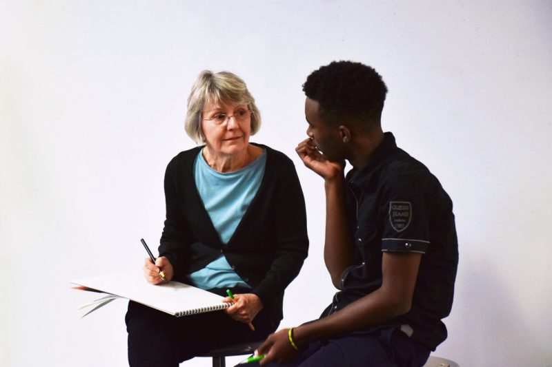 Professor Donna Dunay discusses and assignment with student Jaylen Wooten.