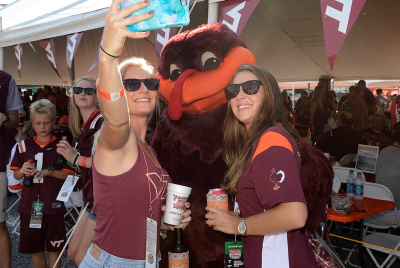 The HokieBird and two fans pose for a selfie