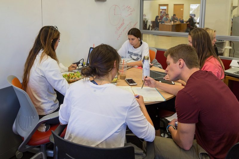 A group of students study in a new enclosed space on the fourth floor of Newman Library.
