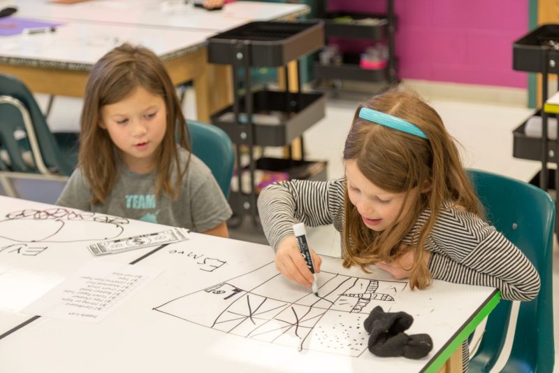 Two first-grade students hit the drawing boards to sketch out their ideas for an invention during an activity in the Cedar Point Tech Lab.