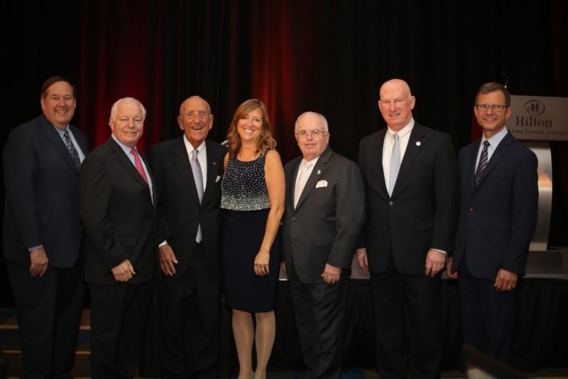 Howard Feiertag poses with six other guests, including hospitality executives.