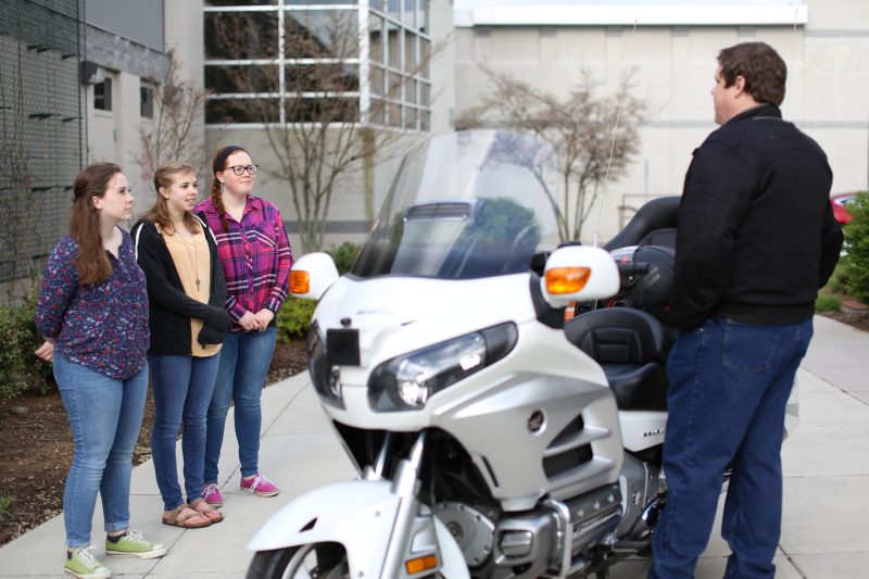 Robert McCall, a research associate at the Virginia Tech Transportation Institute, discusses motorcycle safety research with local high school students during the institute's School Day program.