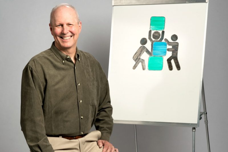 Terry Cobb poses with a illustration of  teamwork.