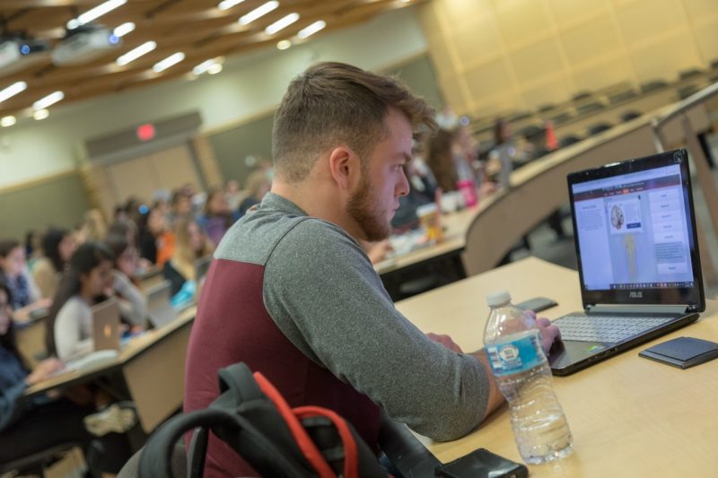 Man looks at laptop in class