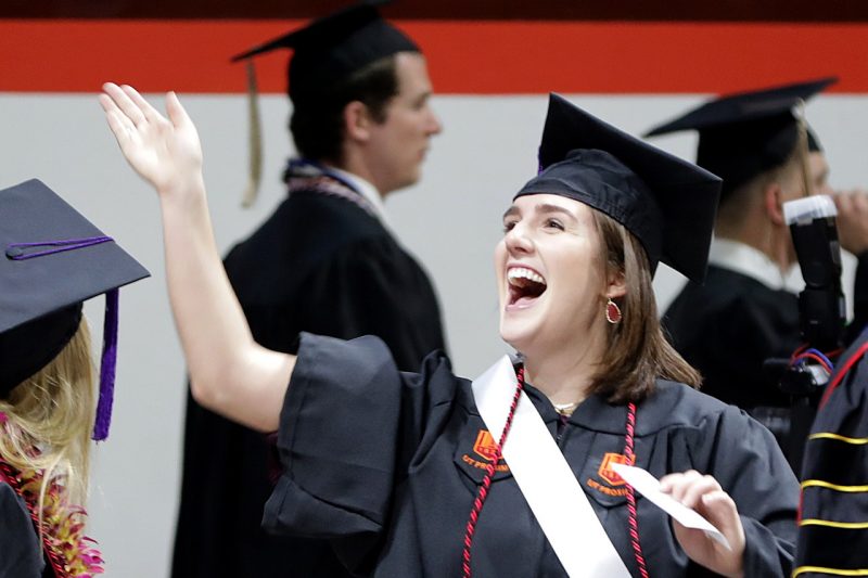 Girl waves during commencement