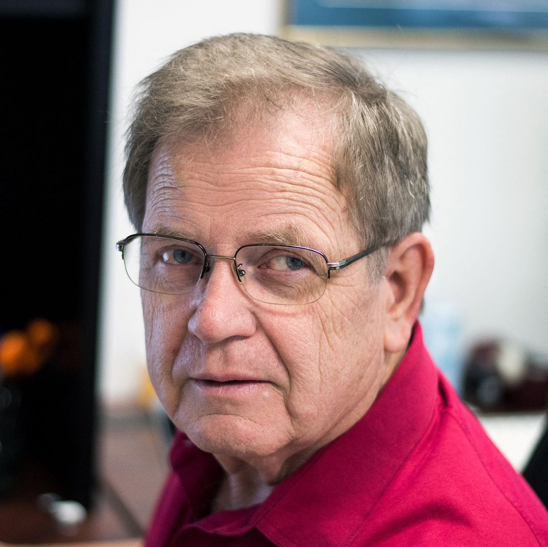 Portrait of Professor Hendricks wearing a red-collared shirt