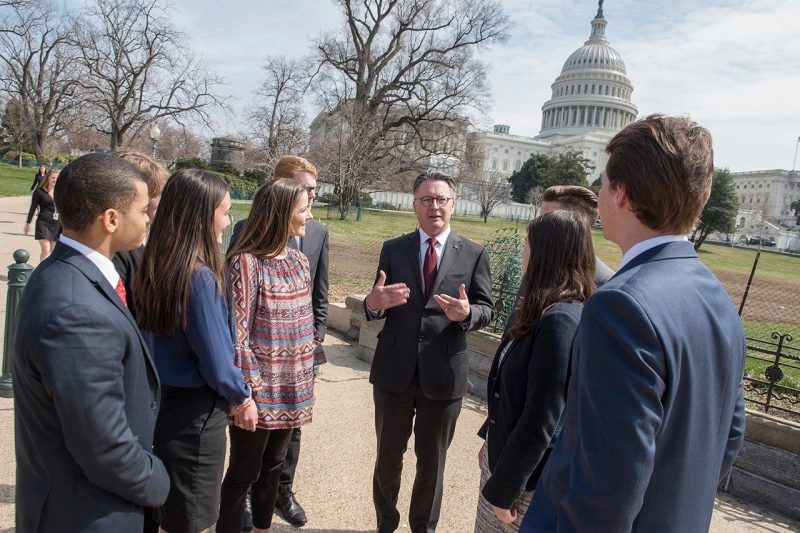 President Sands speaks to a group of students in front of the Capitol dome.