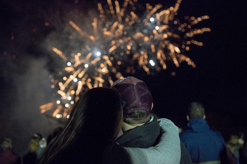 A couple looks up at fireworks at the Spirit Rally