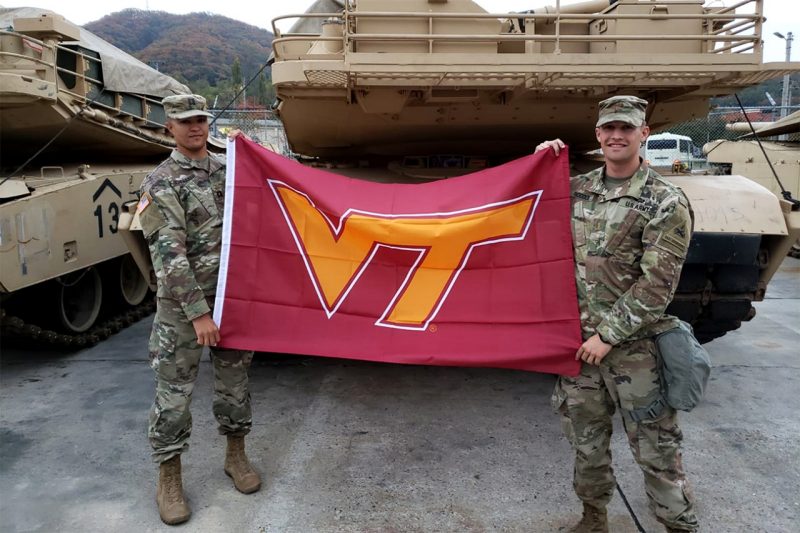 U.S. Army Capt. Matthew Schenaker, at left, a 2011 graduate of the Virginia Tech Corps of Cadets, holds a Virginia Tech flag with U.S. Army 2nd Lt. Benjamin Paddock, a 2017 alumnus.