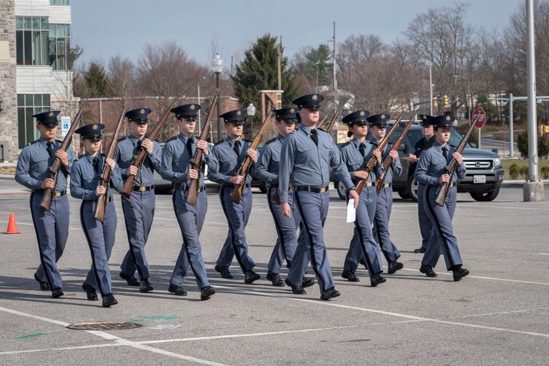 A squad of cadets performs a drill routine.