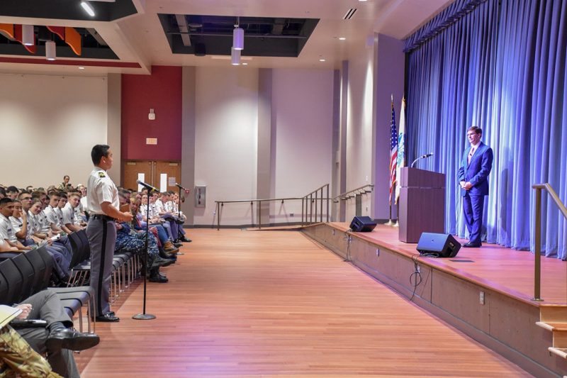 Cadet Matt Krusiac, at left, asks Secretary of the U.S. Army Mark T. Esper a question during a town hall-style meeting .