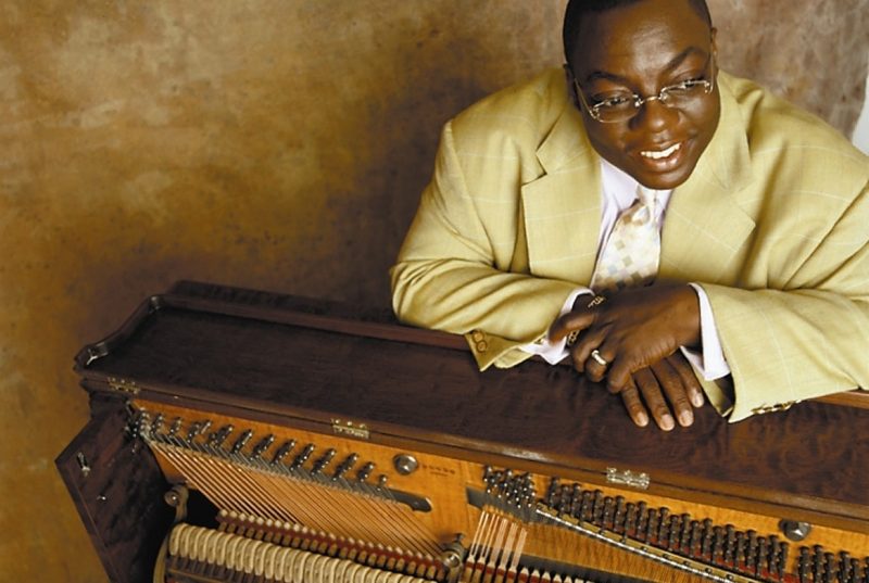 Pianist Cyrus Chestnut poses with a piano.
