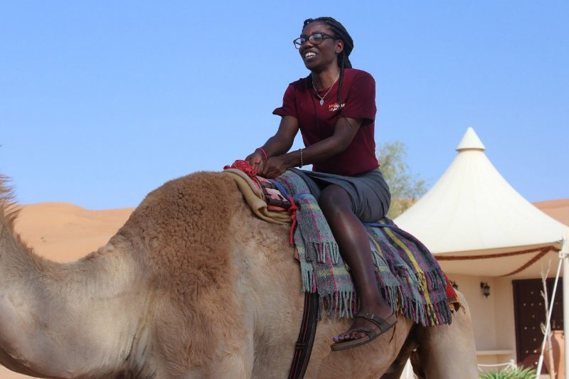 Katherine Louis rides a camel in Oman. 