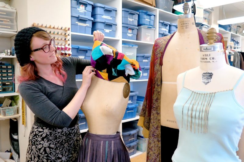 Graduate student Laura Vitale makes adjustments on a costume piece on a dress form.