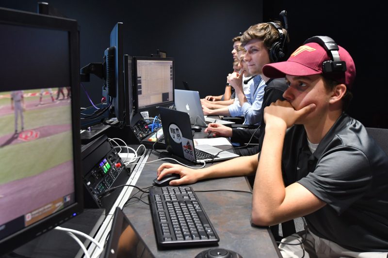 Students working at computers in a control room.