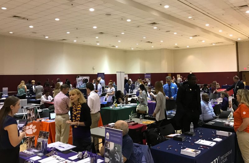 Students talk with recruiters at display tables at the Graduate and Professional School Fair in the Commonwealth Ballroom