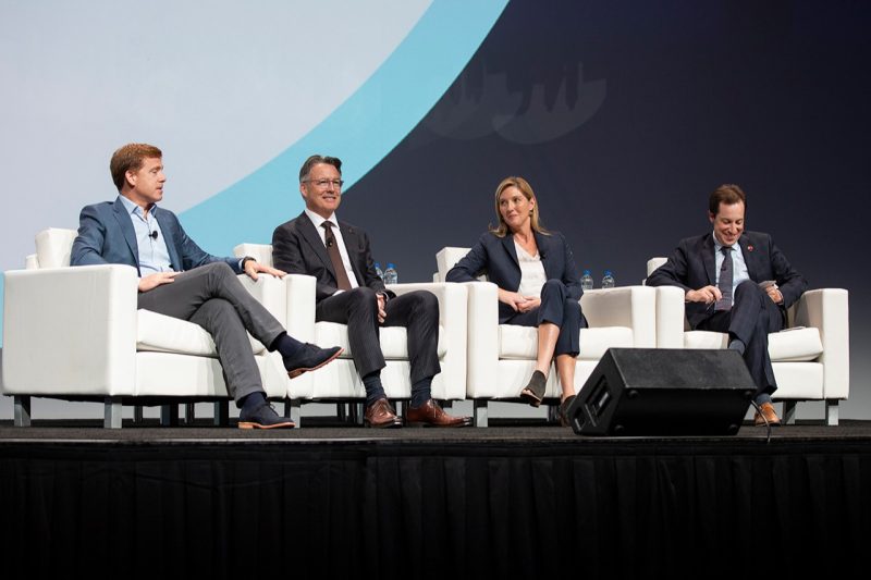 Four people on a stage at a conference for urban development