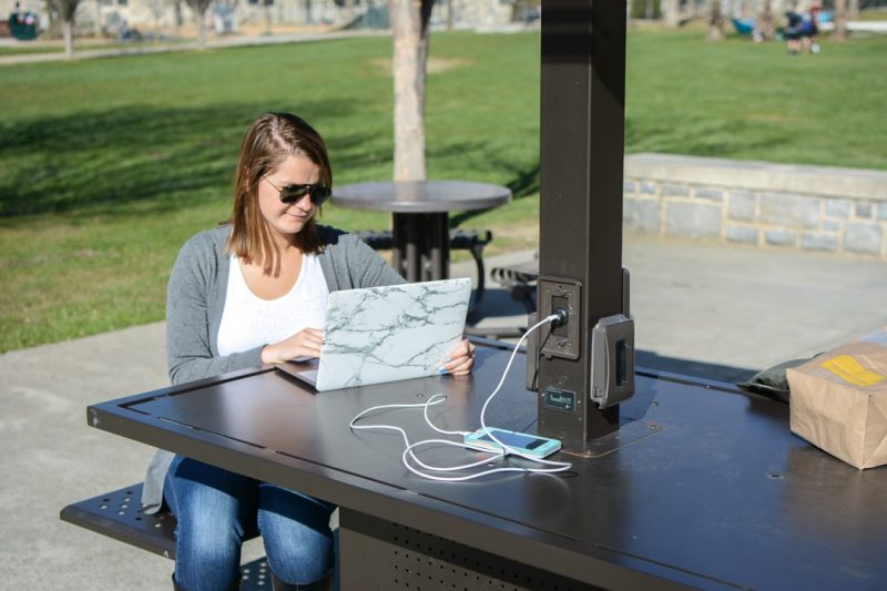 Student sitting at solar charging table