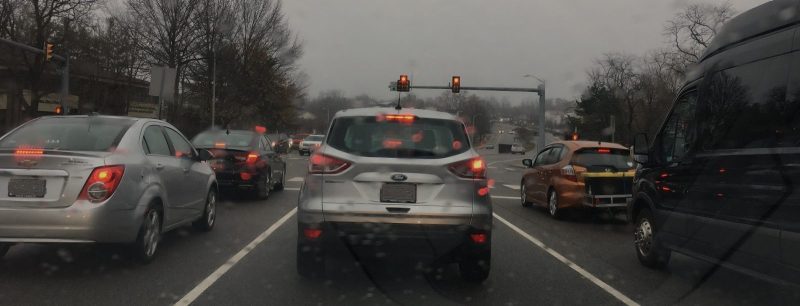 Multiple cars at a traffic stop on a foggy, rainy day