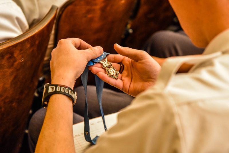 A cadet holds a Medal of Honor in his palm.