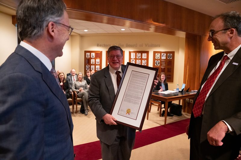 Virginia Tech President Tim Sands, left, and Board of Visitors Rector Horacio Valeiras, right, present Dwight Shelton, center, with his emeritus resolution during the November Board of Visitors meeting.