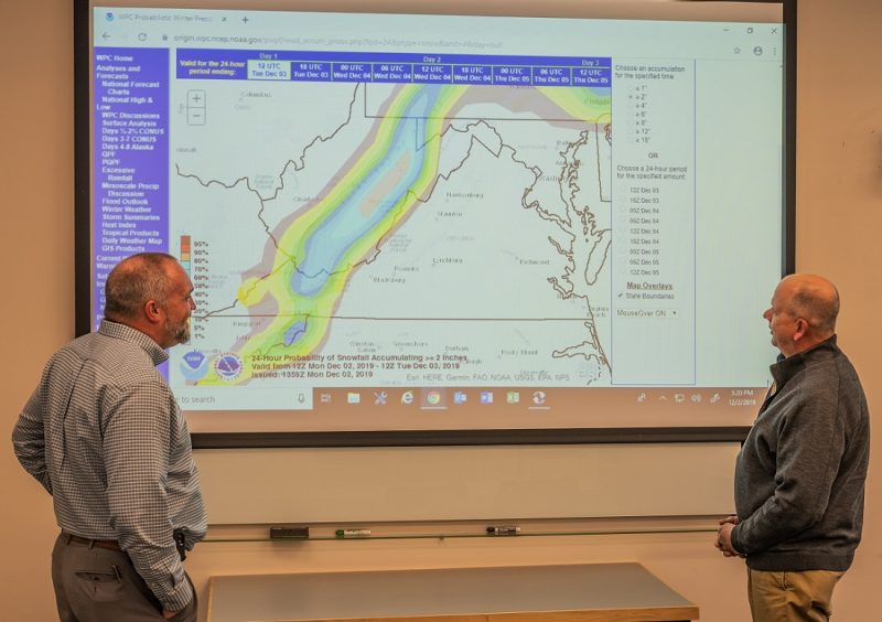 Anthony Watson and John Beach of Virginia Tech Facilities monitoring a weather map projected on a screen