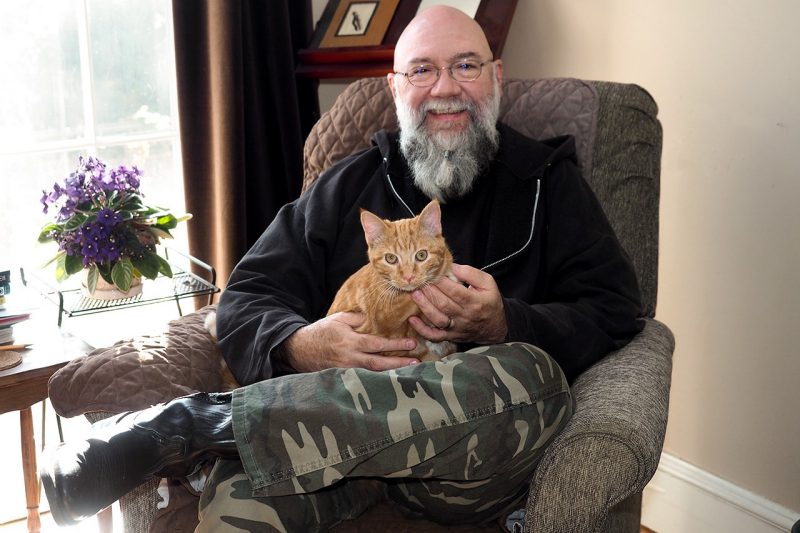 Jeff Mann sits in the comfort of his writing space with Rory, an orange tabby cat, on his lap.