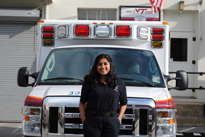 Areej Khan, a member of the Virginia Tech Rescue Squad, stands in front of a Rescue Squad ambulance.