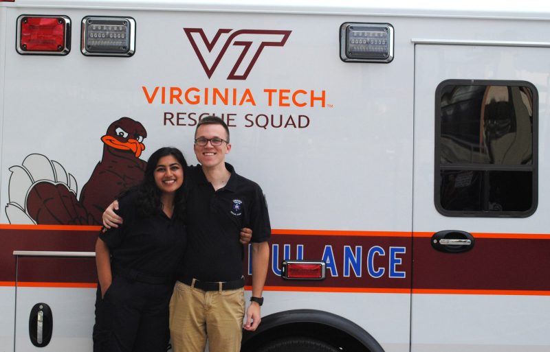 Areej Khan (left) stands in front of a Virginia Tech Rescue Squad ambulance with Ben Klingaman