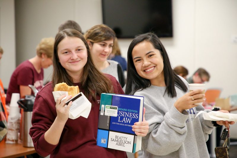 Students study business law while eating grilled cheese in the library.