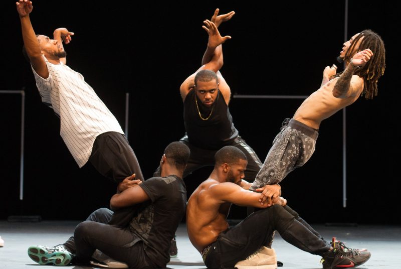Five male dancers for FLEX AVE. strike different poses during a performance onstage.